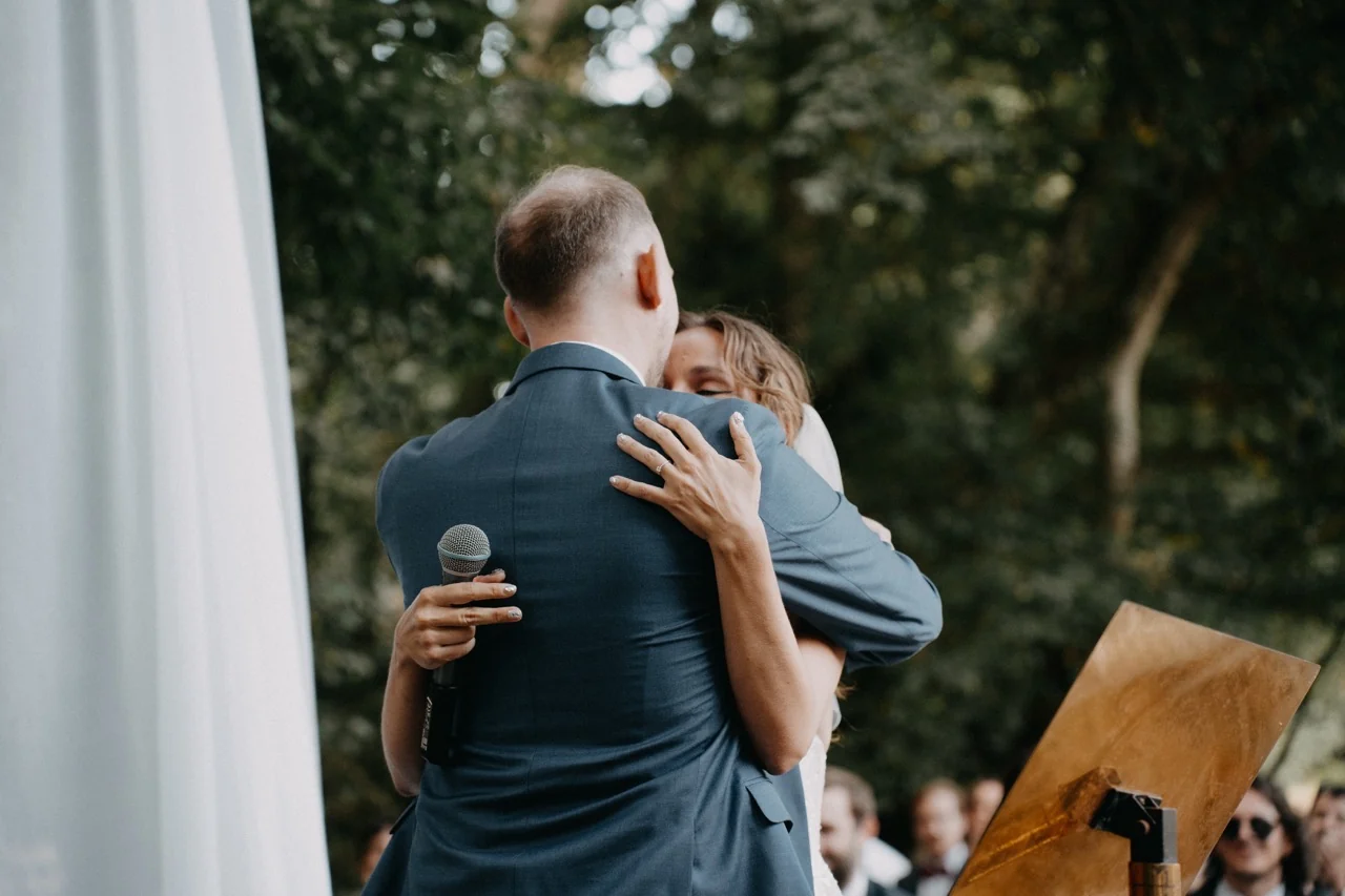Une étreinte pendant une cérémonie de mariage en extérieur