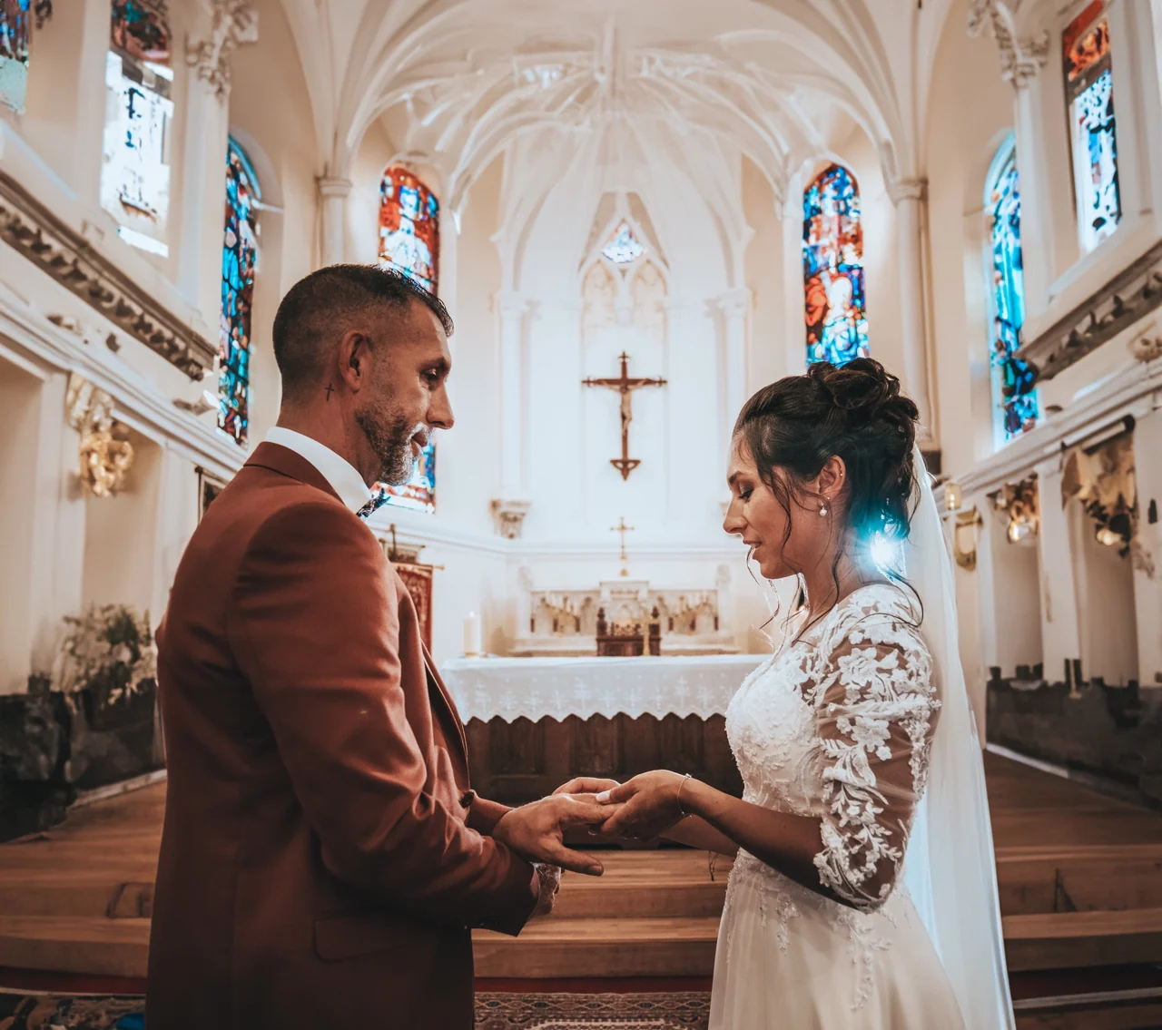 Les mariés se tiennent la main pendant leur cérémonie à l’église