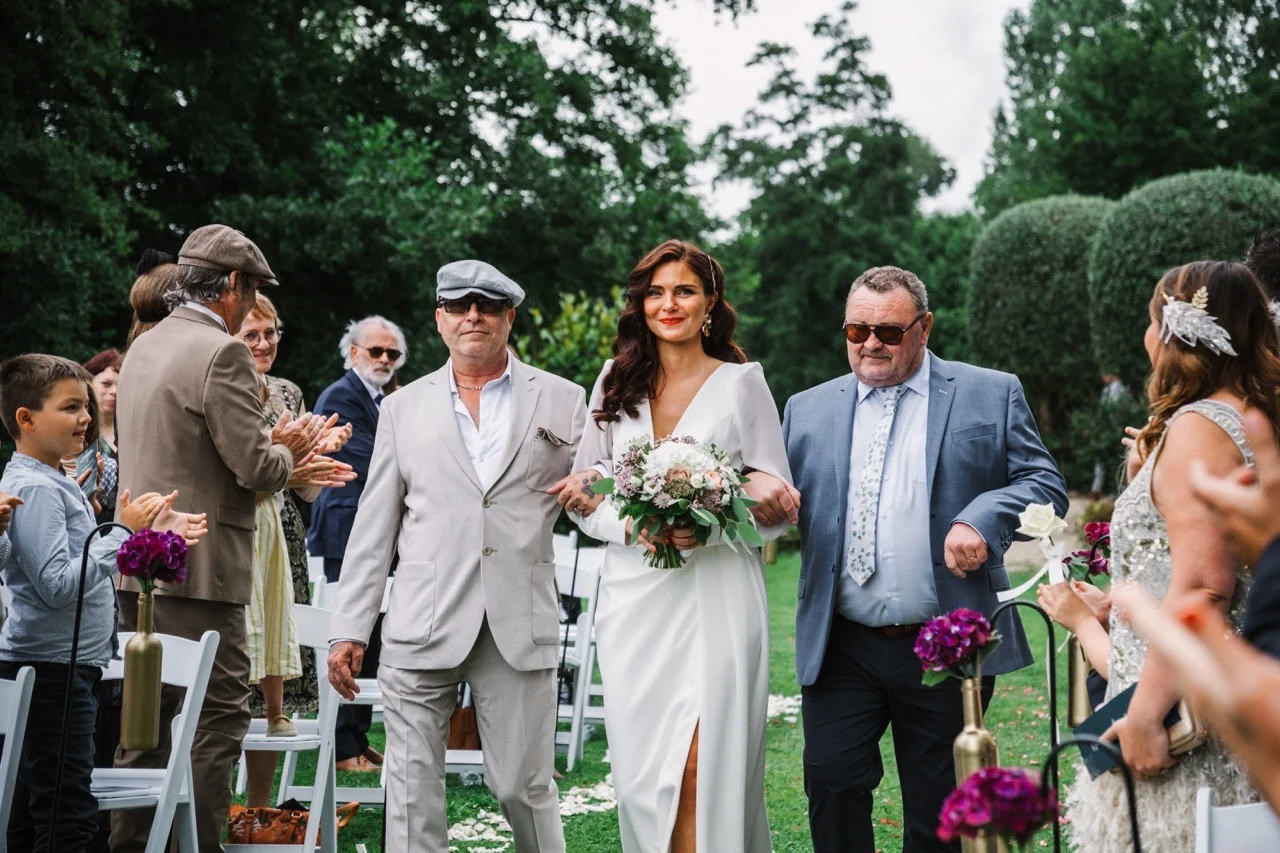 La mariée arrive avec ses proches dans un jardin
