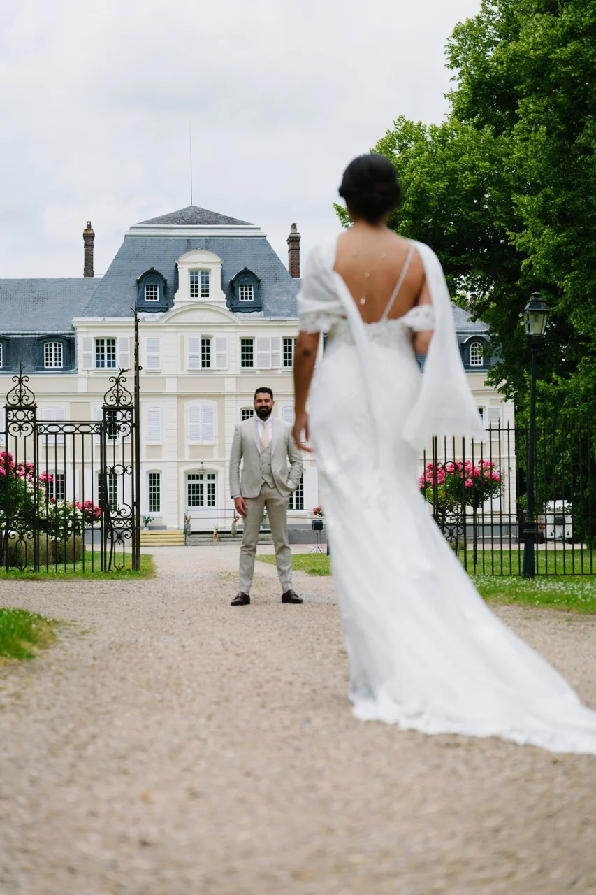 La mariée et sa longue traîne devant le château