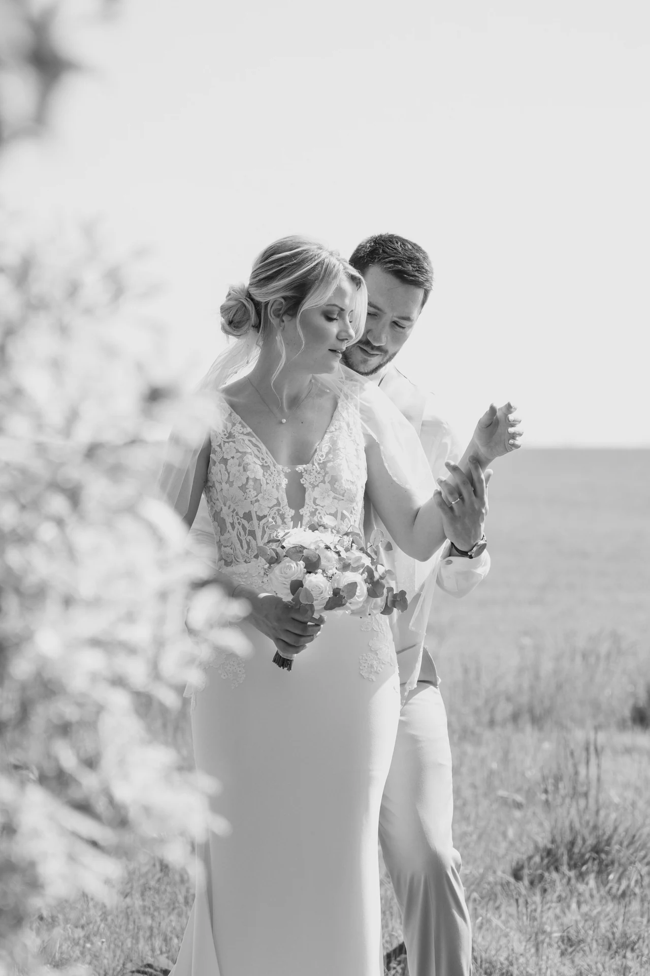 Les mariés enlacés derrière un voile, photographiés en noir et blanc